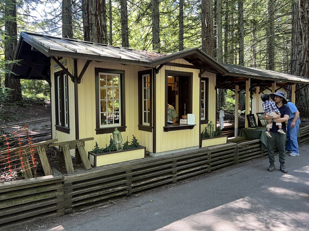 Family waiting outside the quaint ticket station of Redwood Valley Railway surrounded by lush forest in Tilden Regional Park, Orinda, California, July 22, 2023.